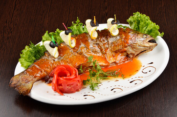 fried fish with lemon and olives, beautifully served in a restaurant