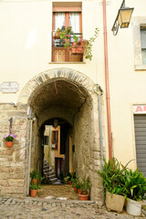 Fototapeta na wymiar A street between old medieval stone buildings of Sonnino, a historic town in Lazio region, Italy.