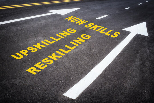 Newskills, upskilling and reskilling with white arrow sign marking on road surface for giving directions.