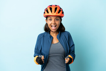 Young cyclist woman isolated on blue background celebrating a victory in winner position - obrazy, fototapety, plakaty