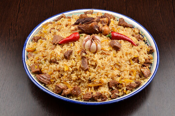 Asian pilaf garnished with paprika and garlic with large pieces of meat