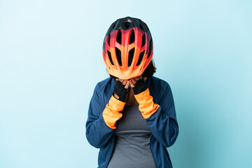 Young cyclist woman isolated on blue background with tired and sick expression - obrazy, fototapety, plakaty