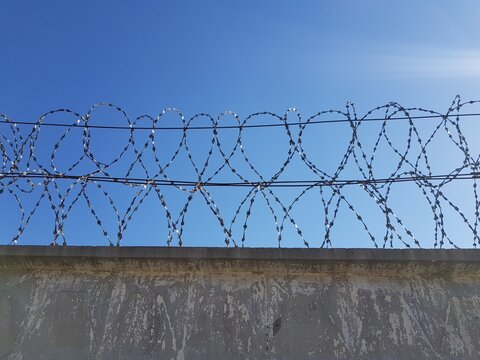 Metal barbed wire on a stone fence