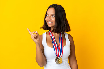 Young asiatic woman with medals isolated on white background intending to realizes the solution while lifting a finger up