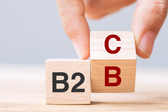 hand change wooden cube block from B2C to B2B. E Commerce, marketing and strategy concepts