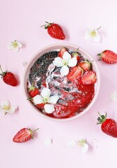 Wood charcoal detoxification. smoothie bowl. detox food - chia seeds with coal, smoothies from strawberries and yogurt. useful breakfast with strawberries in a pink bowl on a pink background. 