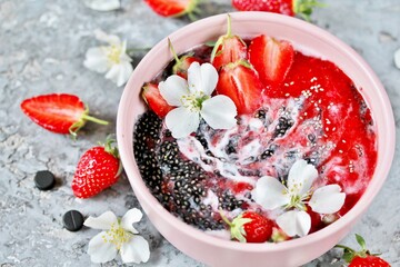 Wood charcoal detoxification. smoothie bowl. detox food - chia seeds with coal, smoothies from strawberries and yogurt. useful breakfast with strawberries in a pink bowl on a pink background. 