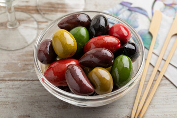 Glass bowl with a variation of different olives close up for a snack 
