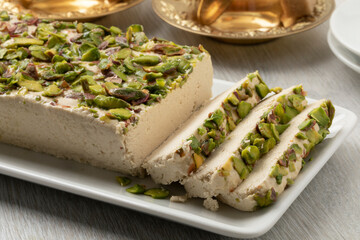 Plate with traditional Turkish pistachio halva and slices close up  
