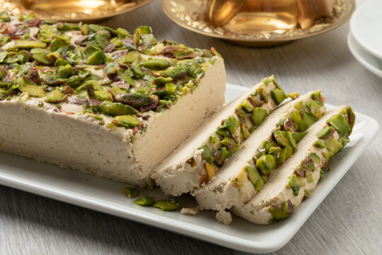 Plate with traditional Turkish pistachio halva and slices close up  