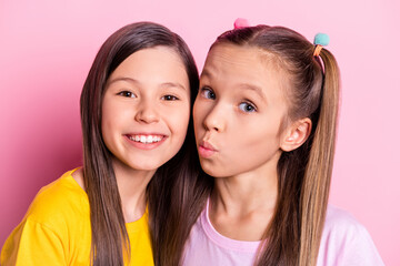 Photo of optimistic brunette blond girls kiss wear yellow pink t-shirt isolated on pastel pink...