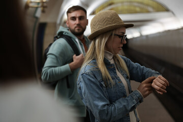 Young woman waiting for train at subway station. Public transport