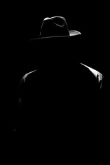 dark mystical silhouette of a man in a hat at night