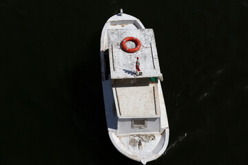 White motor fishing boat on a river in top view. 