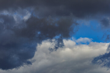 Dark storm clouds on a bright blue sky. Sky patterns background 2021.