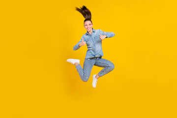 Fototapeta na wymiar Full length body size photo young pretty girl jumping up showing thumb-up sign isolated bright yellow color background
