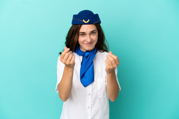 Airplane stewardess woman isolated on blue background making money gesture