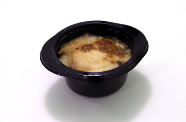 Julienne fast food ready to eat after warm in microwave oven. Unhealthy food. Frozen ready meals in plastic container. White background.