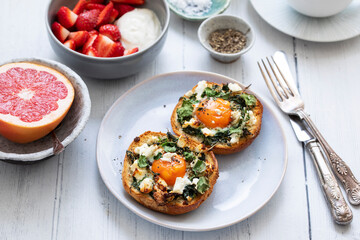 Eggs baked inside brioche bun with watercress and feta