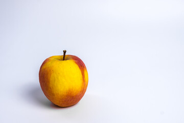 Isolated  of white wallpaper of Spoiled red Apple with wrinkle surface that became yellow.