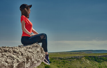 Naklejka na ściany i meble girl in sportswear at the top of the mountain