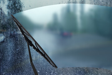 Car windshield wiper cleaning water drops from glass while driving - obrazy, fototapety, plakaty