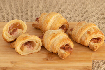 Croissants  stuffed with calabreza on cutting board.