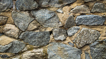 masonry of stones of different sizes in gray, background or texture 