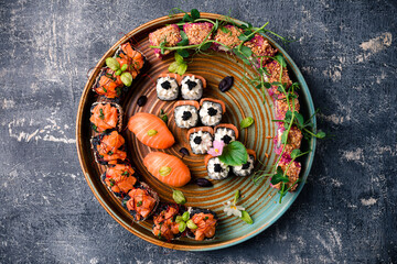 Fototapeta na wymiar Various kinds of sushi roll set served on black stone. Japanese food