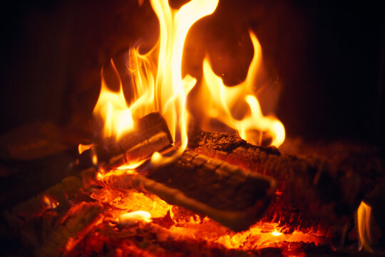 A fire burns in a fireplace, Fire to keep warm. Logs burning in a fireplace