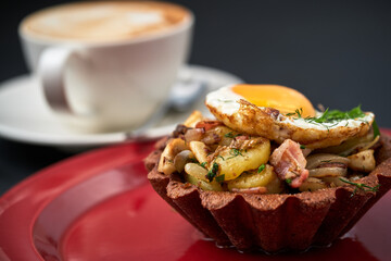 basket with bacon fried potatoes and egg and a cup of coffee break