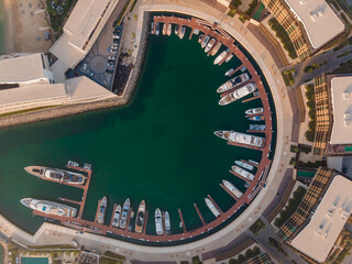 An Aerial shot of circular Marina where many yachts are docked
