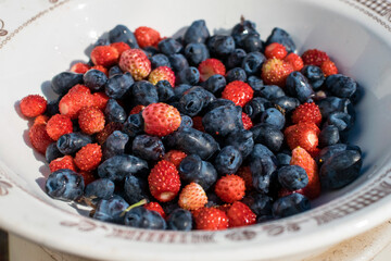Fresh strawberries and blue honeysuckle on a plate