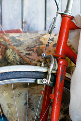 Wheel and part of the handlebars of old red bicycle