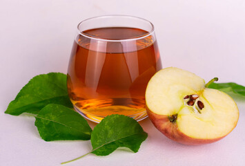 Glass with organic apple juice on a white background.
Close-up.