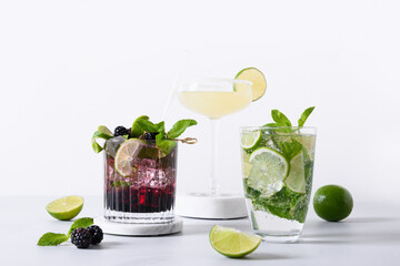 Classic and blackberry mojito, margarita cocktail with lime on modern color background. Three summer freshness beverage for festive party. Summer holiday mocktail.