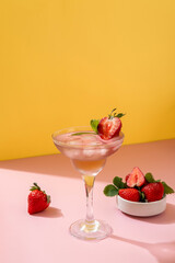 Summer mojito cocktail with strawberries on yellow background. Strawberry Mojito. Refreshing summer drink with copy space