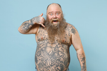 Young fat pudge obese chubby overweight blue-eyed bearded man has big belly with naked tattooed...