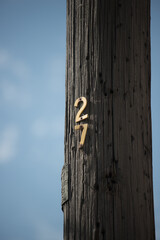number twenty-seven or 27 on a wooden pole on a blue sky