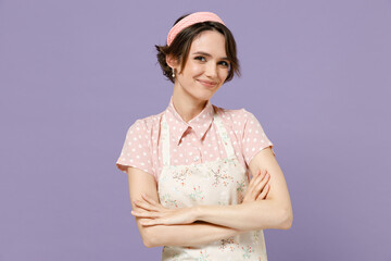 Young happy caucasian housewife housekeeper chef cook baker woman wear pink apron t-shirt hold hands crossed folded isolated on pastel violet color background studio portrait. Cooking food concept