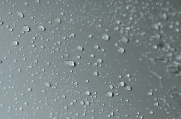 The texture of a water drop on a gray background. Closeup