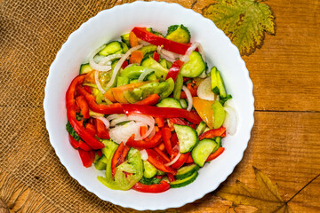 Salad from tomato, cucumbe, pepper and onion in white plate
