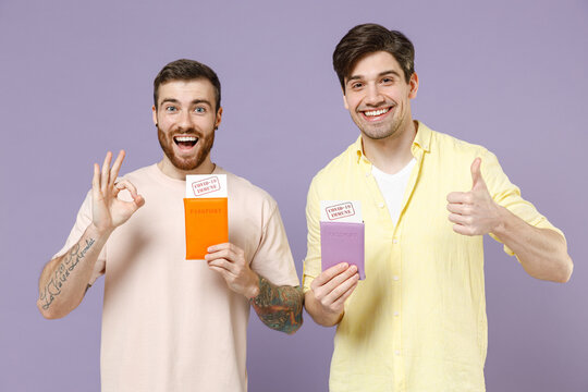 Two Tourist Men Friends In Tshirt Tattoo Translate Fun Point Finger Passport Covid19 Immunity Show Ok Thumb Up Isolated On Purple Background Passenger Travel Abroad Weekend Getaway Air Flight Concept