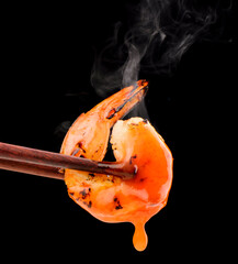 Hot Grilled Shrimp BBQ style with sauce and smoke Contains spicy ingredients Seafood close-up photo isolated on black background