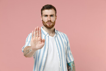 Young serious confident caucasian unshaven man 20s wearing blue striped shirt white t-shirt do stop...