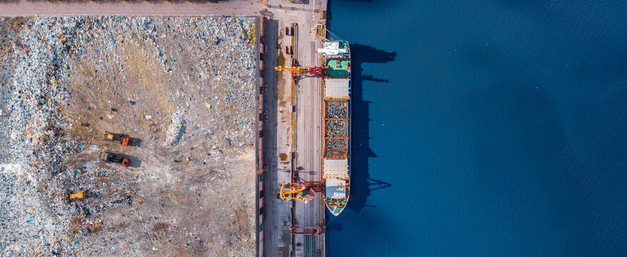 Waste loading at port cargo ship transports of garbage for recycling factory. Concept plastic Pollution environment, aerial top view