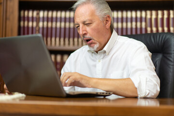 Tired and bored businessman working in his office