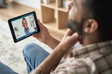 Young indian latin bearded businessman having videocall meeting at home with black female doctor...