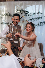 The bride and groom in the banquet hall are receiving congratulations. Newlyweds at the wedding table.
