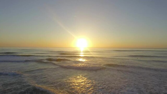 Aerial view from a panoramic drone on the paradise beach, sunset, surfer in the water, Anglet, France